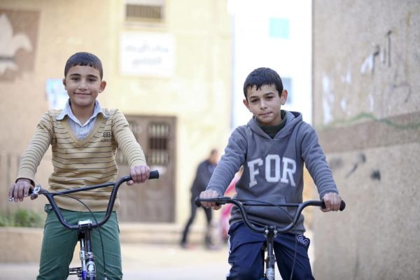 refugee-kids-bicycles-streets